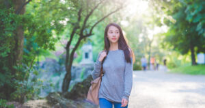 木漏れ日の中を歩く女性 - 散歩でクリエイティブなアイデアを生み出す